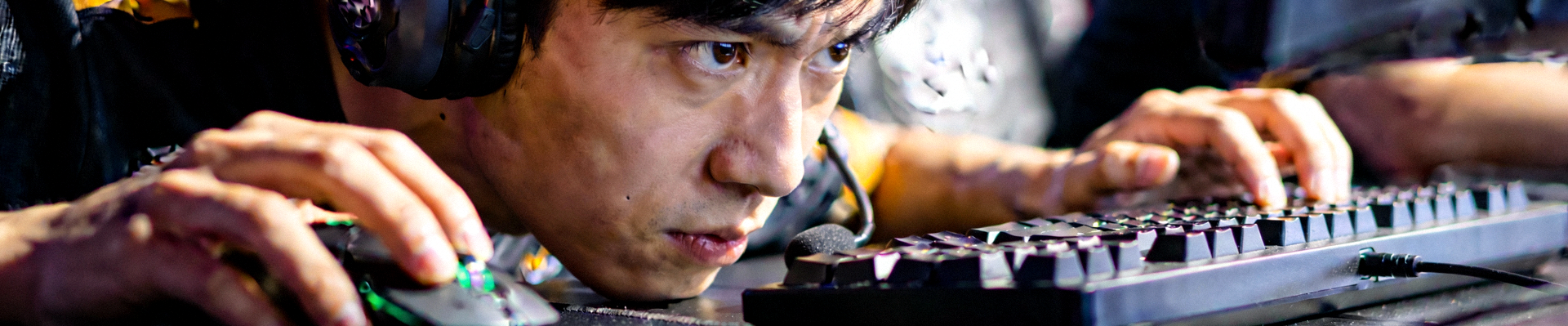 电竞选手专注比赛的特写镜头 - 戴着耳机神情严肃操作键盘鼠标